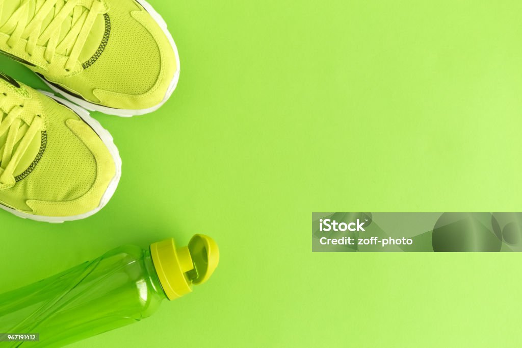 High angle view of trainers and bottle Flat lay of sport exercise equipment green minimal creative concept. Space for copy. Backgrounds Stock Photo