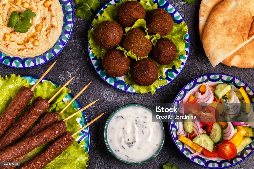 Classic kebabs, falafel and hummus on the plates. Classic kebabs, falafel and hummus on the plates. Top view. Food Stock Photo
