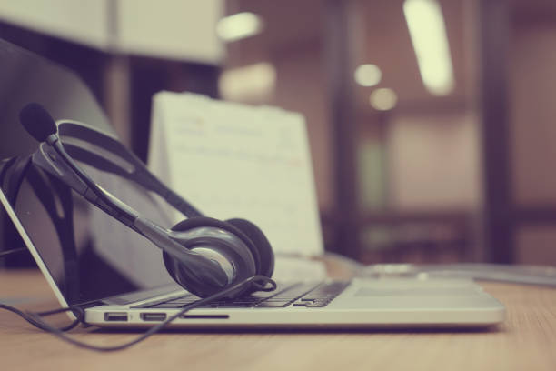 istock close up focus on call center headset device at telephone VOIP system at office desk for hotline telemarketing concept 967202998
