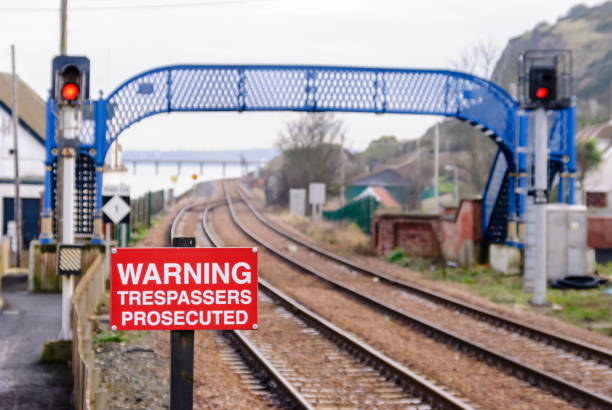 istock Warning sign and a pedestrian footbridge over railway tracks. 967221256