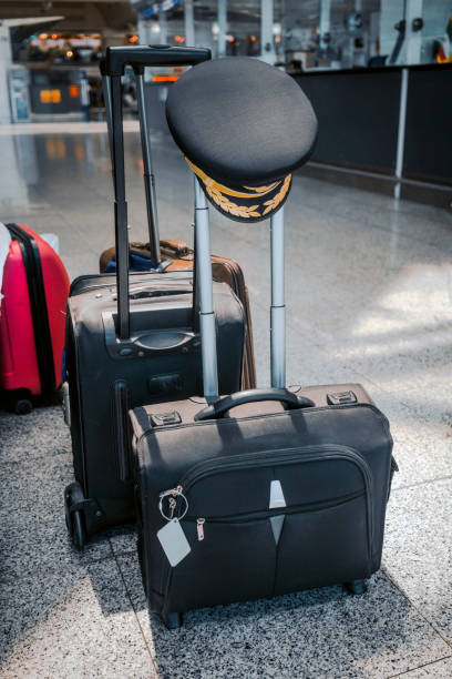 istock pilot cap hanging on handle of suitcase at airport 967229638