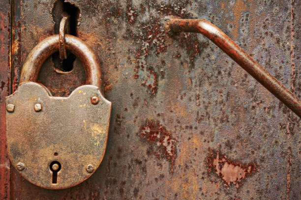 istock An old metal dirty rusty door with a padlock. Abstract background. 967232064