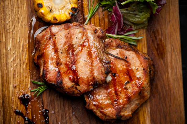 istock two grilled steaks with corn and salad on a wooden plank 967254816