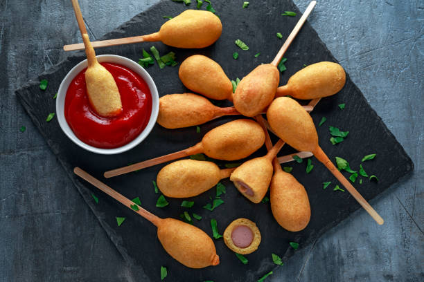 мини кукурузные собаки на каменном блюде с кетчупом - corn dog стоковые фото и изображения