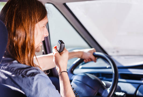 istock Young man driving car using cb radio 967276016