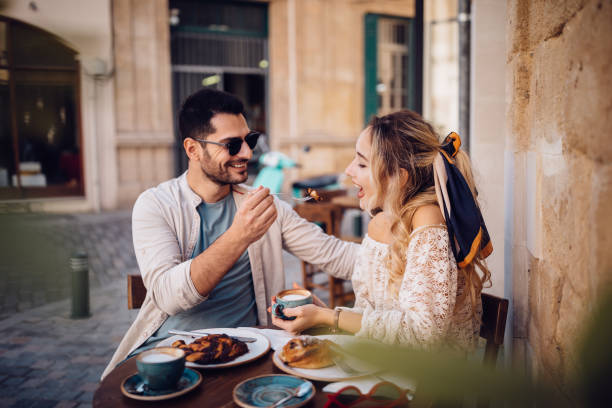 istock Young couple eating snacks and drinking coffee at Italian cafe 967276508