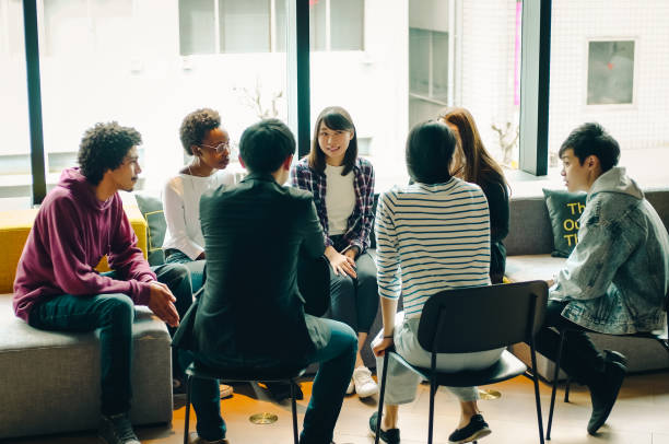 młodzi mężczyźni i kobiety dyskutują w kawiarni. - business asian ethnicity multi ethnic group business meeting zdjęcia i obrazy z banku zdjęć