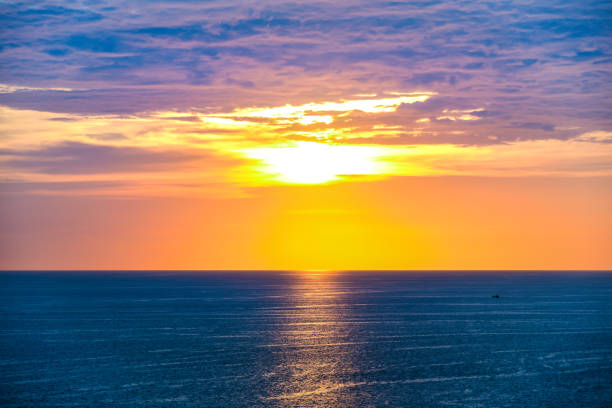 panorama view of sunset twilight sky and sea ocean on summer season with tiny sillhouette fishing boat at far away