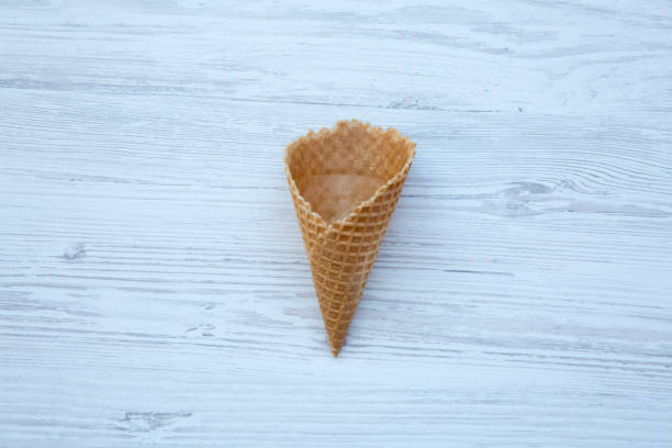 istock Waffle sweet cone over white wooden background, flat lay. From above, top view. 967296632