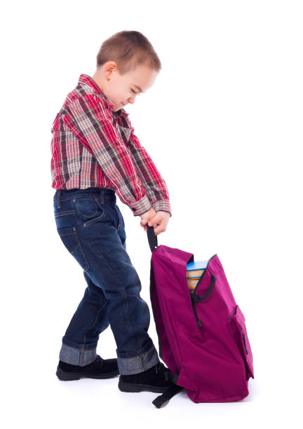 Little boy with heavy schoolbag stock photo
