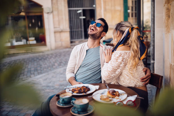 Young couple drinking coffee and having fun at coffee shop Tourists on summer holidays in Europe having coffee and snacks at old town traditional cafe spanish breakfast stock pictures, royalty-free photos & images