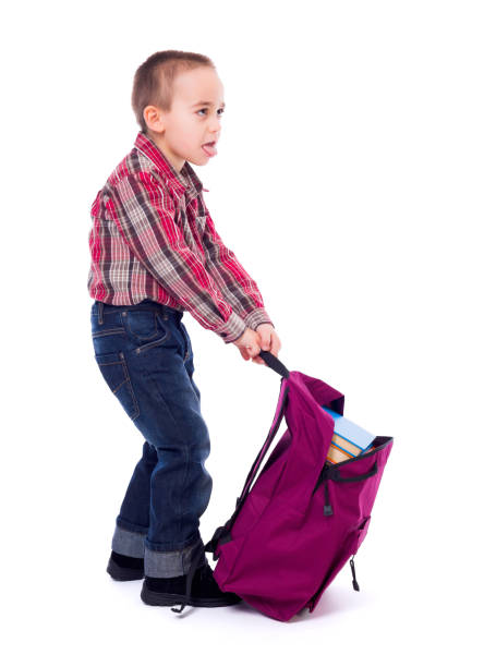 Little boy with heavy schoolbag stock photo