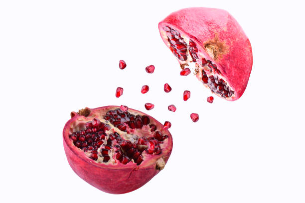 istock Pomegranate in flight burst on a white background, isolated. Cut half pomegranate flying in the air. Pomegranate fruit explosion 967312098