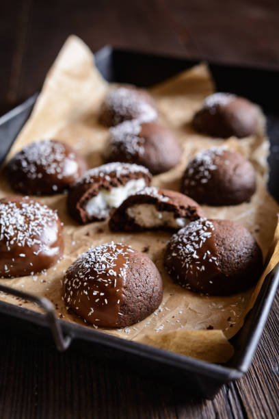 istock Cocoa biscuits with coconut filling, decorated with chocolate and grated coconut 967315178
