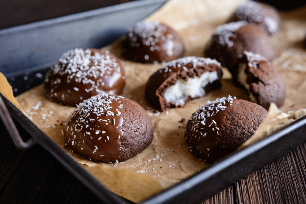 istock Cocoa biscuits with coconut filling, decorated with chocolate and grated coconut 967315190