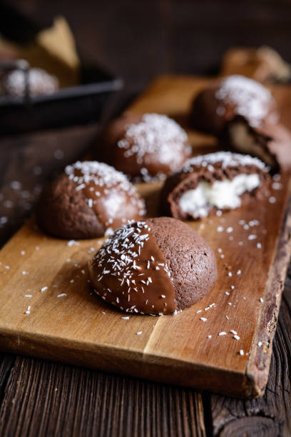 istock Cocoa biscuits with coconut filling, decorated with chocolate and grated coconut 967315210