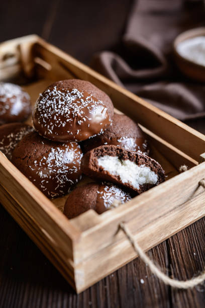 istock Cocoa biscuits with coconut filling, decorated with chocolate and grated coconut 967315220