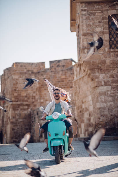 istock Young friends having fun riding scooter in old Mediterranean town 967315488