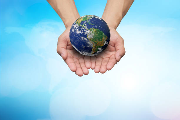 istock Two hands holding the earth in palm gesture on blurred blue map color gradient background.Elements of this image furnished by NASA 967315660