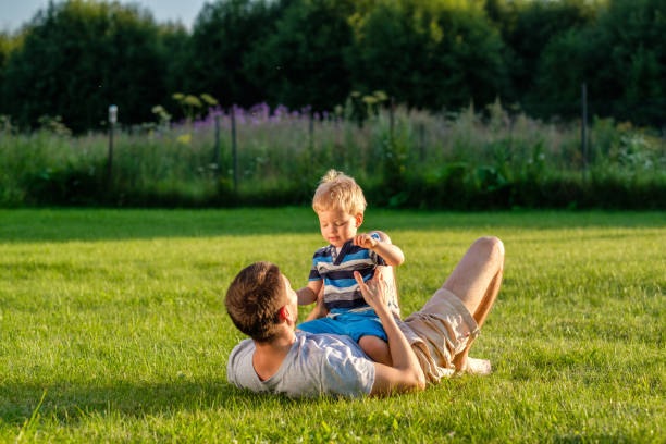 istock Happy father and son having fun outdoor on meadow 967318176
