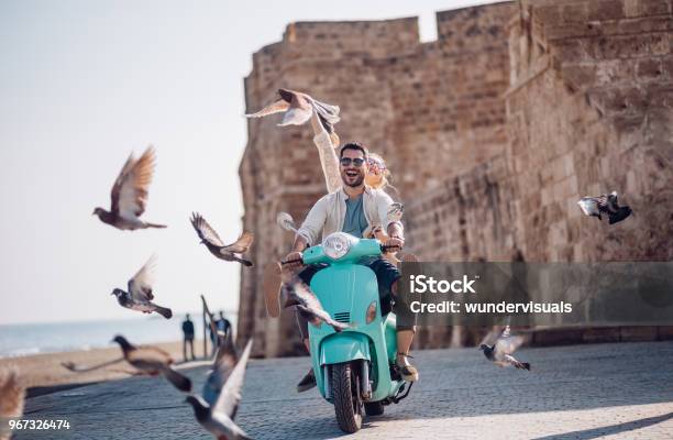 Young Couple Having Fun Riding Scooter In Old European Town Stock Photo - Download Image Now
