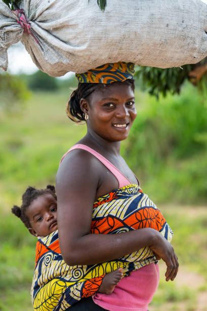 An African girl laying on the beach and smiling at the camera.