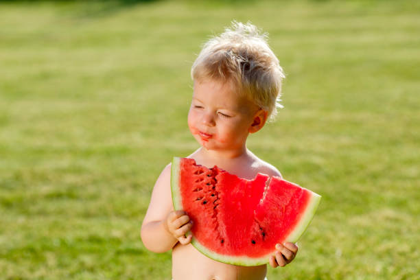 정원에서 수 박 먹고 1 년 된 아기 - watermelon missing bite melon grass 뉴스 사진 이미지