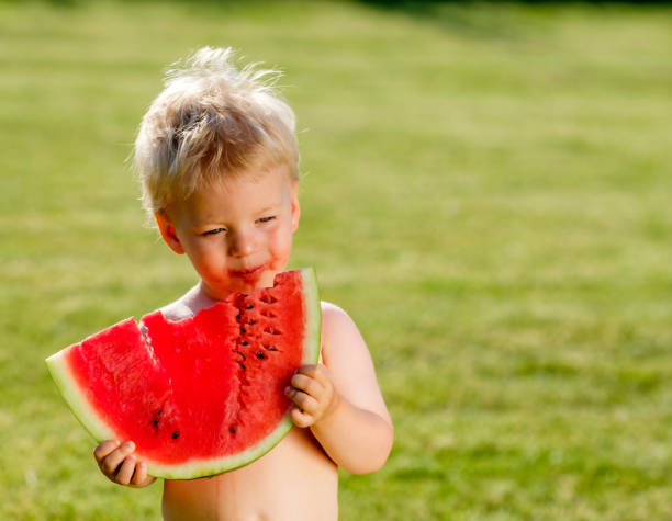 정원에서 수 박 먹고 1 년 된 아기 - watermelon missing bite melon grass 뉴스 사진 이미지