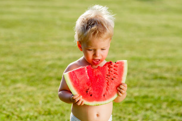 정원에서 수 박 먹고 1 년 된 아기 - watermelon missing bite melon grass 뉴스 사진 이미지