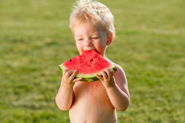 정원에서 수 박 먹고 1 년 된 아기 - watermelon missing bite melon grass 뉴스 사진 이미지