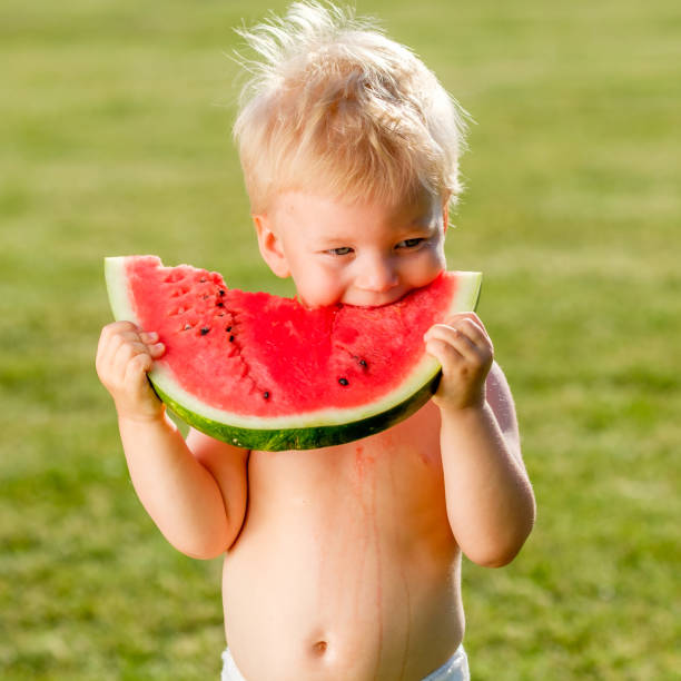 정원에서 수 박 먹고 1 년 된 아기 - watermelon missing bite melon grass 뉴스 사진 이미지