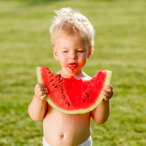 정원에서 수 박 먹고 1 년 된 아기 - watermelon missing bite melon grass 뉴스 사진 이미지