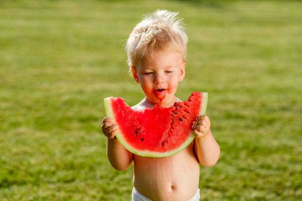 정원에서 수 박 먹고 1 년 된 아기 - watermelon missing bite melon grass 뉴스 사진 이미지