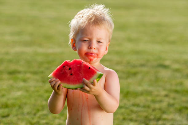 정원에서 수 박 먹고 1 년 된 아기 - watermelon missing bite melon grass 뉴스 사진 이미지