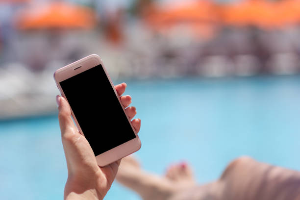 istock Woman hand using smartphone near swiming pool 967332460