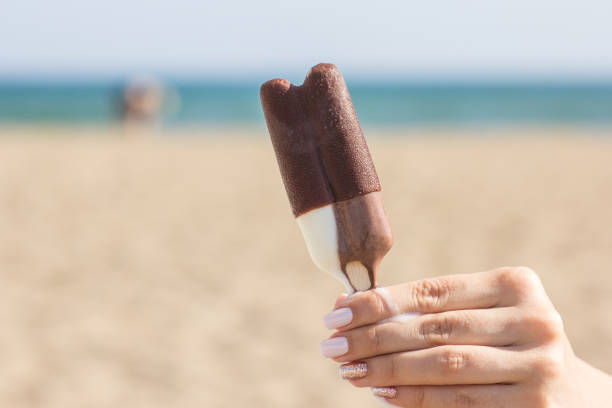 istock Girl holding ice cream and summer beach background 967332508