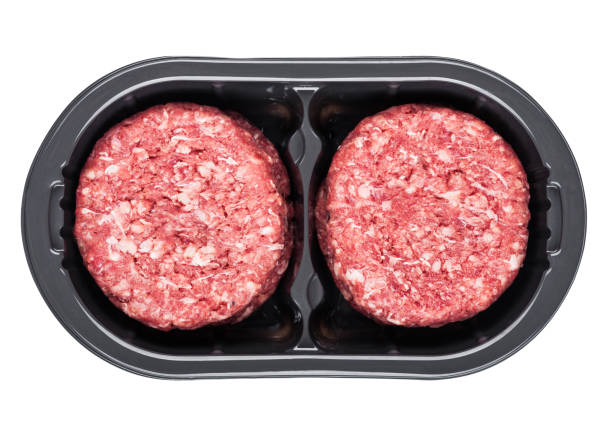 istock Raw fresh beef burgers in plastic tray on white 967335378