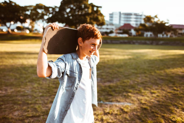 istock sad kid with the skateboard on the shoulder 967345914