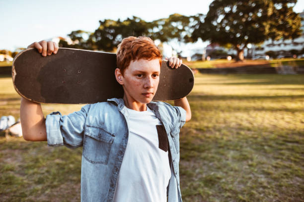 istock sad kid with the skateboard on the shoulder 967345946