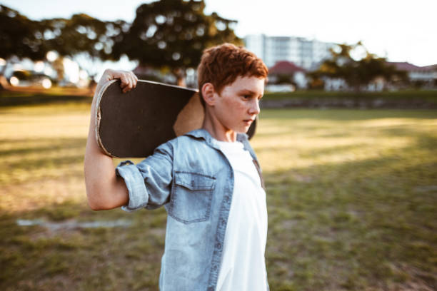 istock sad kid with the skateboard on the shoulder 967346012