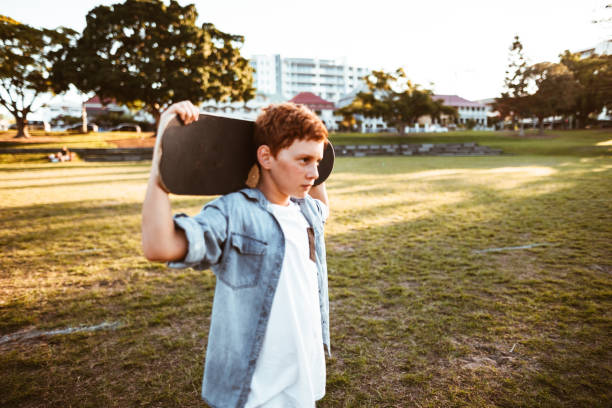 istock sad kid with the skateboard on the shoulder 967346110