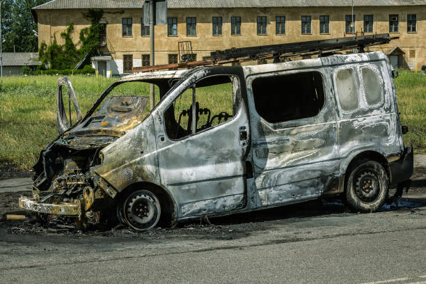 istock Fully burned car on a road 967348374