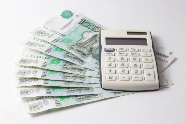 istock Money with a calculator lying on a white background 967350976