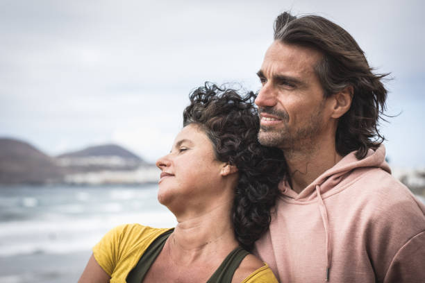 Young woman leaning on boyfriend's chest while enjoying sea views. Expectant, chill out look concept
