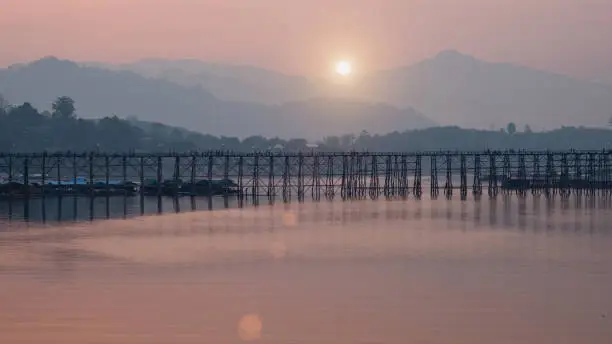 This Wooden Mon Bridge is officially named Uttama Nusorn Bridge with sun light in ter morning. It was built in order to connect with Mon village and Songalia village in Kanchanaburi , Thailand