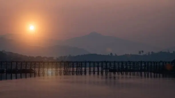 This Wooden Mon Bridge is officially named Uttama Nusorn Bridge with sun light in ter morning. It was built in order to connect with Mon village and Songalia village in Kanchanaburi , Thailand