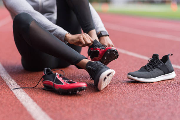istock Athlete changes into her track shoes on a stadium field 967439062