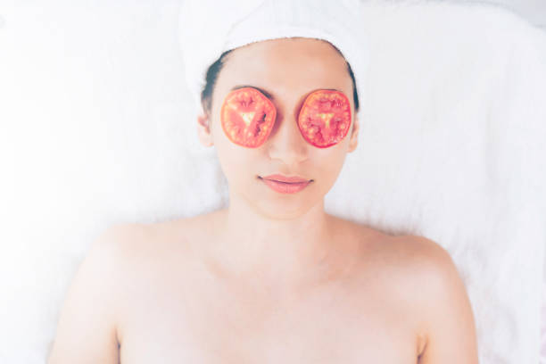 istock Woman getting eye nature treatment by tomato. 967439490