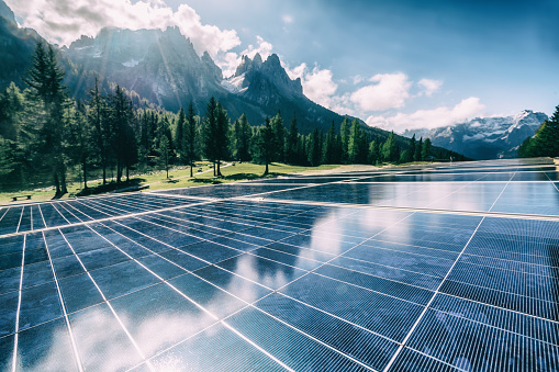 Solar cell panel in country landscape against sunny sky and mountain backgrounds. Solar power is the innovation for sustainability of world energy. Sustainable resources.