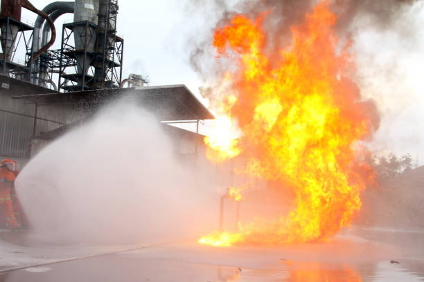 istock fireman using water and extinguisher to fighting with fire flame in an emergency situation.All firemen wearing fire fighter suit for safety. 967489740